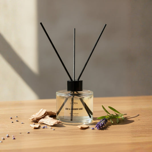Liora Scentique Oak & Lavande Luxe reed diffuser with black reeds, oak chips, and fresh lavender sprig on a wood table