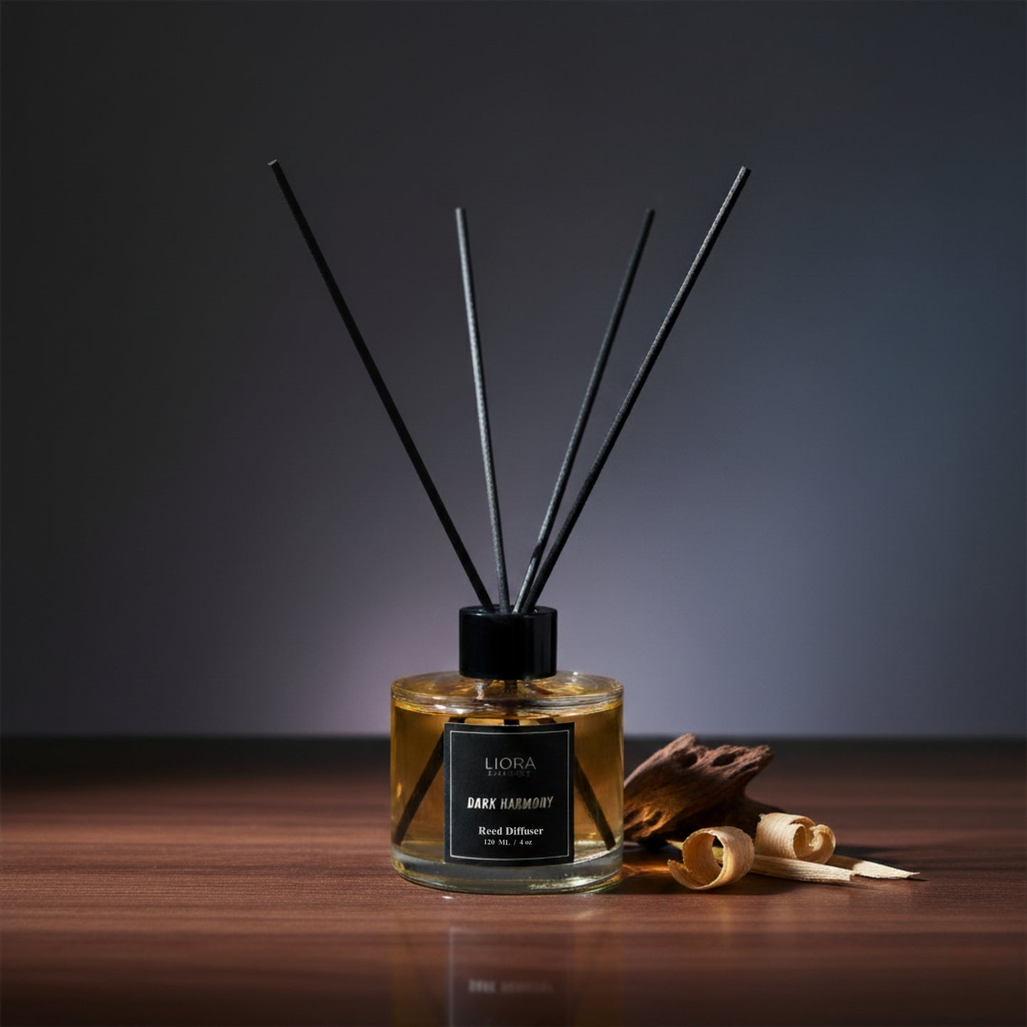 Liora Scentique Dark Harmony reed diffuser with rich yellow oil and black reeds on a marble table with soft lighting, symbolizing luxury sandalwood and oud notes.