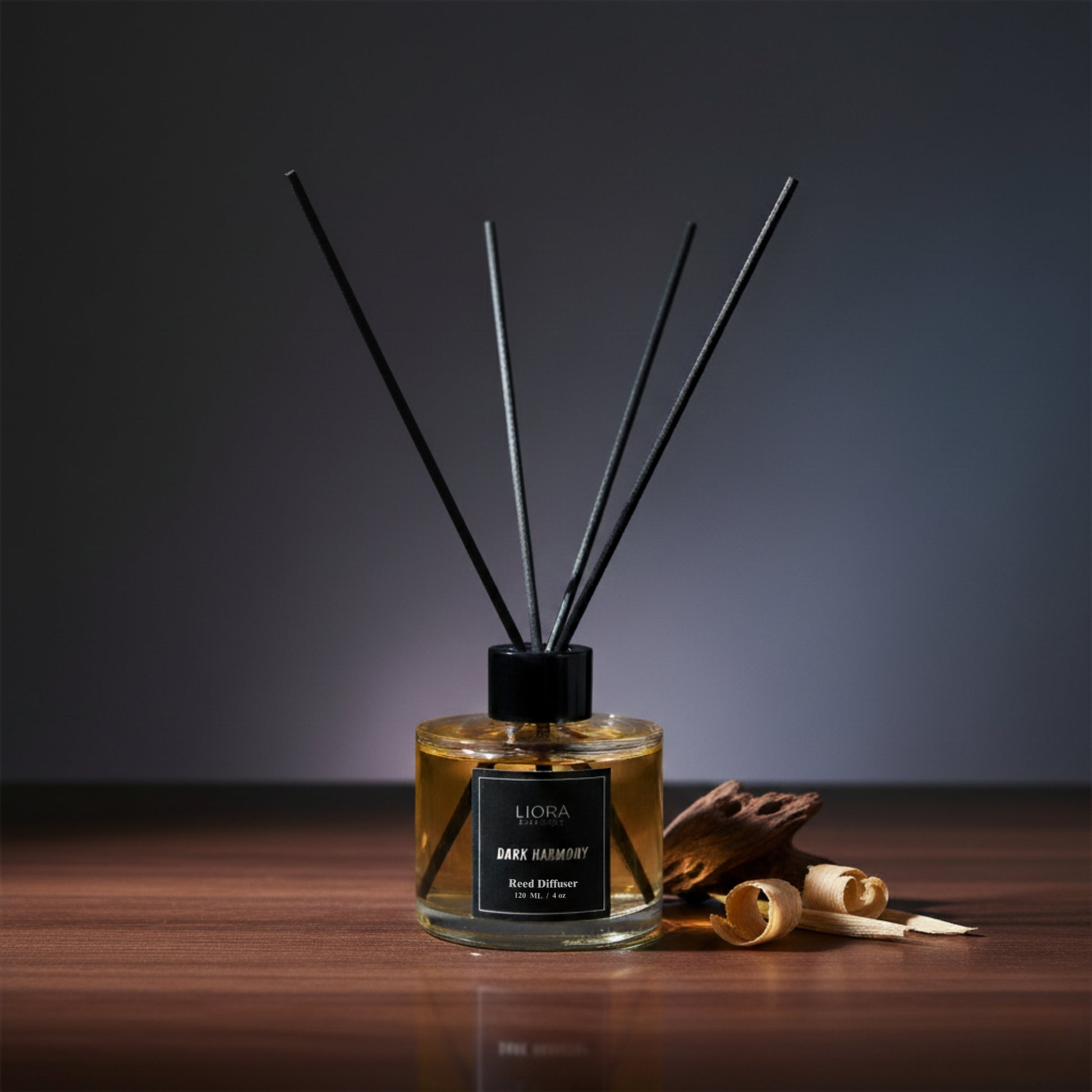 Liora Scentique Dark Harmony reed diffuser with rich yellow oil and black reeds on a marble table with soft lighting, symbolizing luxury sandalwood and oud notes.