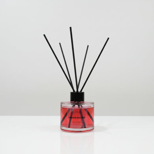 Reed diffuser with black sticks in a clear container on a white background